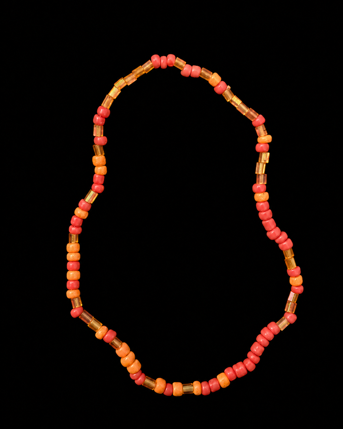 Coral and orange seed bead stretch bracelet with gold-tone bugle bead accents displayed flat in a circle on black background
