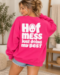 Model showing the white Hot Mess Just Doing My Best back graphic on a hot pink sweatshirt, paired with denim shorts
