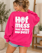Model showing the white Hot Mess Just Doing My Best back graphic on a hot pink sweatshirt, paired with denim shorts
