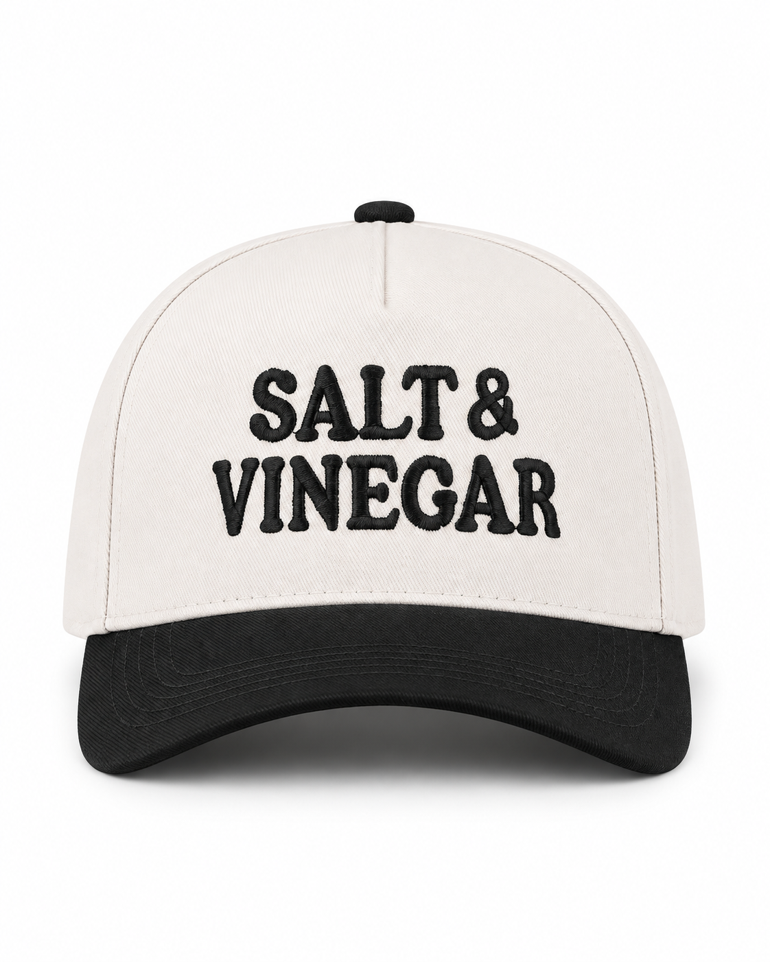 Salt & Vinegar Two-Tone Baseball Cap in Black front view showing cream structured cotton crown with bold black embroidered Salt & Vinegar block lettering, solid black bill, and black top button on white background
