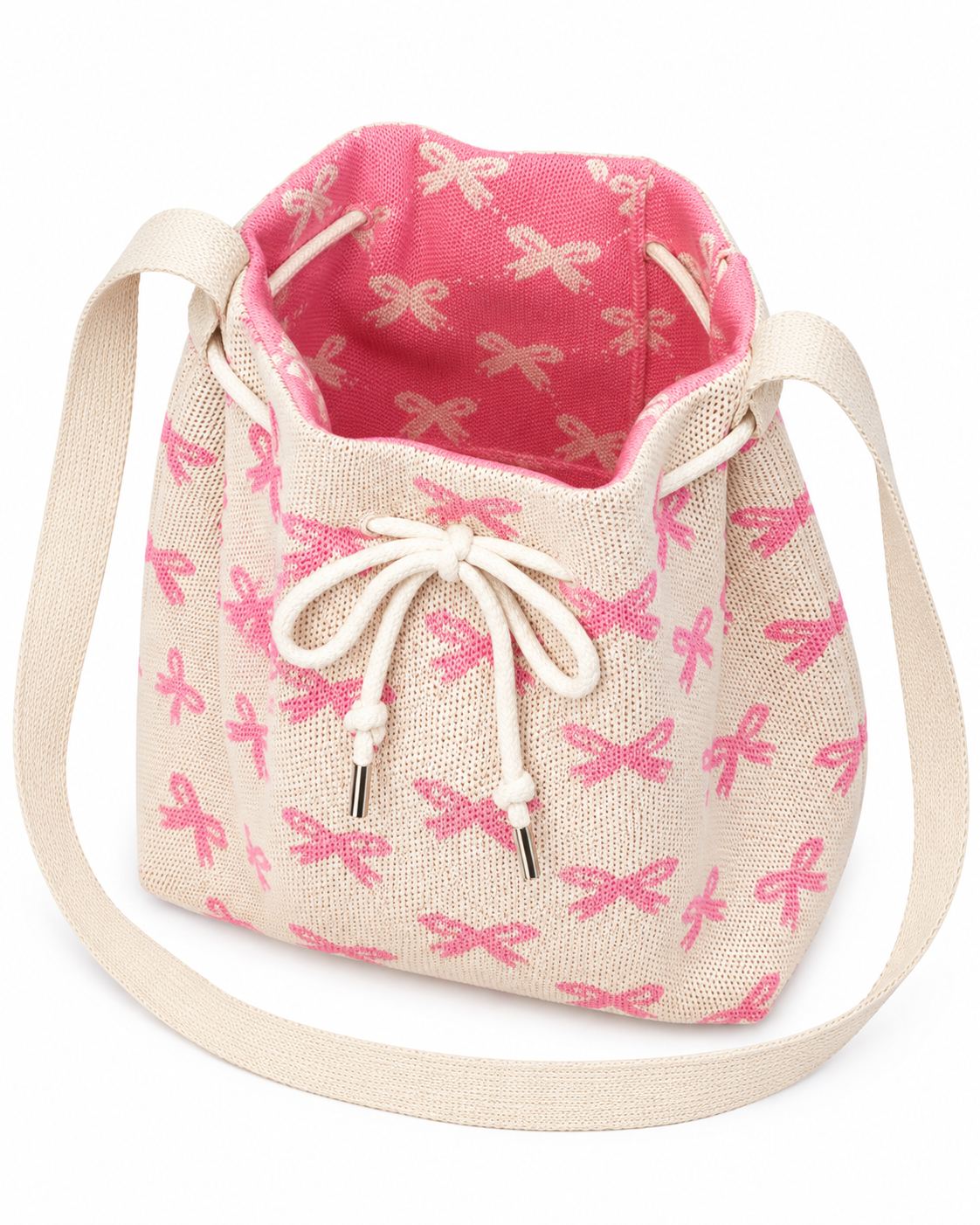 Coquette Bow Crossbody Bucket Bag open interior view showing hot pink woven lining with cream bow pattern, roomy bucket interior, cream rope drawstring pulled open, and wide cream crossbody strap on white background
