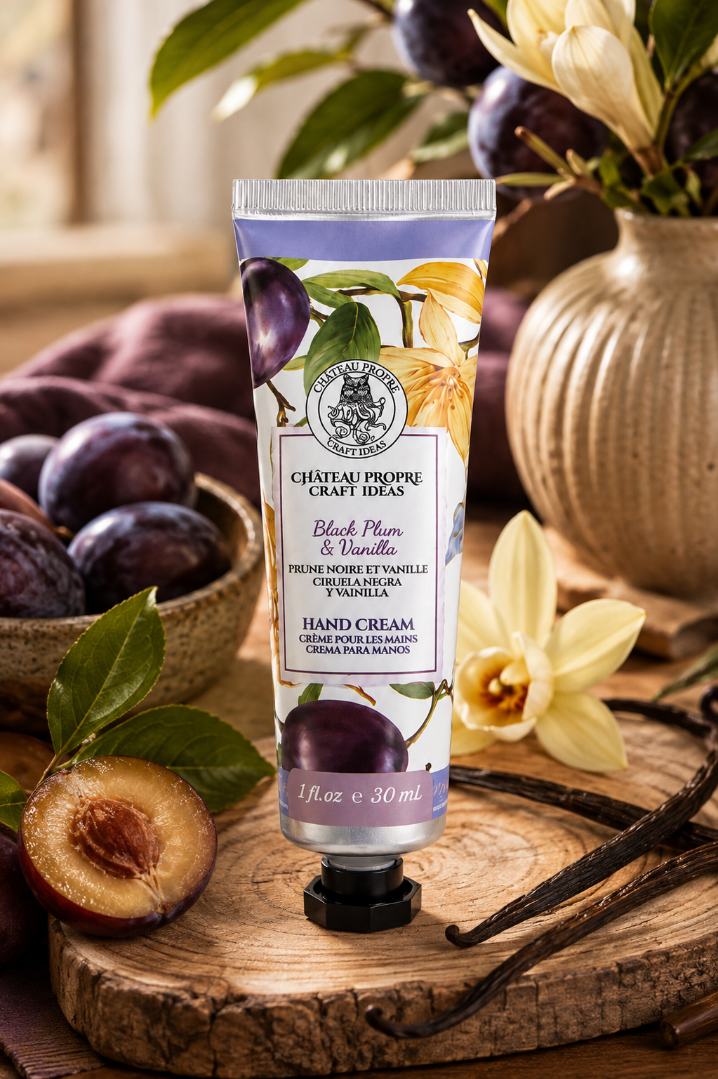 Château Propre Craft Ideas Black Plum & Vanilla hand cream in a 1 fl oz squeeze tube, styled on a rustic wooden board with plums, vanilla beans, and daffodils.