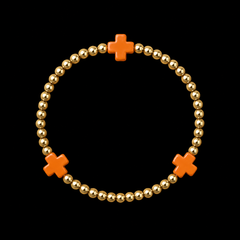 Gold ball bead stretch bracelet with three evenly spaced orange cross accents displayed flat in a circle on black background
