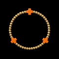 Gold ball bead stretch bracelet with three evenly spaced orange cross accents displayed flat in a circle on black background
