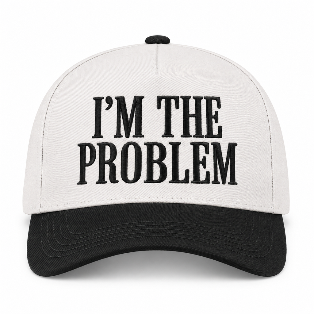 I'm the Problem Baseball Cap in Black front view showing cream cotton crown with black raised serif block I'm the Problem embroidery, solid black bill, and black top button on white background
