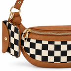 Close-up of Duo Checkered Crossbody Bag in Camel showing gold zipper pull detail along top edge, coordinating black and cream checkered mini wallet clipped to strap with gold carabiner and gold D-ring hardware, and camel tan vegan leather trim with visible stitching on white background

