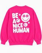 Full back view of the hot pink sweatshirt with white Be a Nice Human lettering and daisy-eye smileys