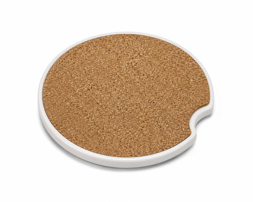 Back of a ceramic car coaster showing natural cork backing and finger notch cutout, on a white background.
