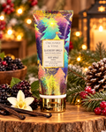 Blackberry Vanilla hand and body lotion displayed with blackberries, vanilla pods, a vanilla flower, and festive evergreen branches
