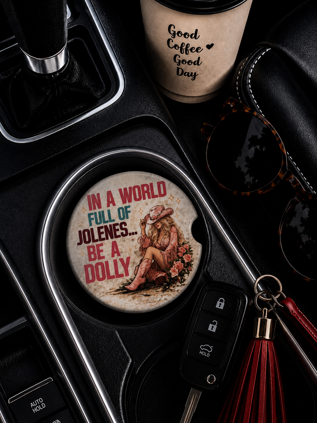In a World Full of Jolenes Be a Dolly ceramic car coaster in cup holder — retro cowgirl in pink hat and boots with roses and bold pink and teal lettering on cream background
