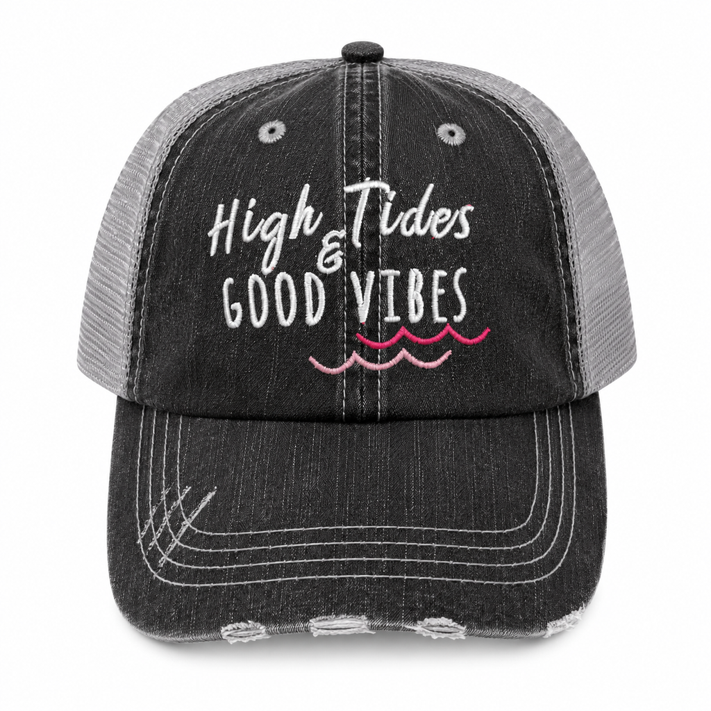 A distressed trucker cap with a black washed denim front and brim, and a gray mesh back. The front features the embroidered text 'High Tides & GOOD VIBES' in white, with pink wavy lines underneath representing water.