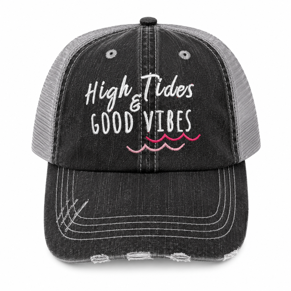 A distressed trucker cap with a black washed denim front and brim, and a gray mesh back. The front features the embroidered text 'High Tides & GOOD VIBES' in white, with pink wavy lines underneath representing water.