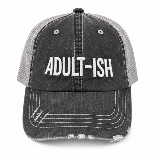 A distressed trucker-style baseball cap with a dark gray washed denim front panel and brim, and light gray mesh back panels. The front features the word 'ADULT-ISH' embroidered in bold white capital letters.