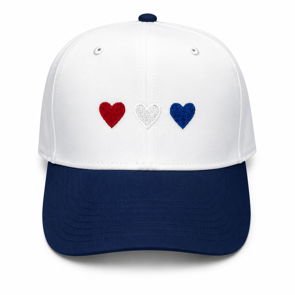 Red White & Blue Hearts Baseball Cap in white crown with navy brim and three embroidered hearts in red, white, and blue, shown on a white background.

